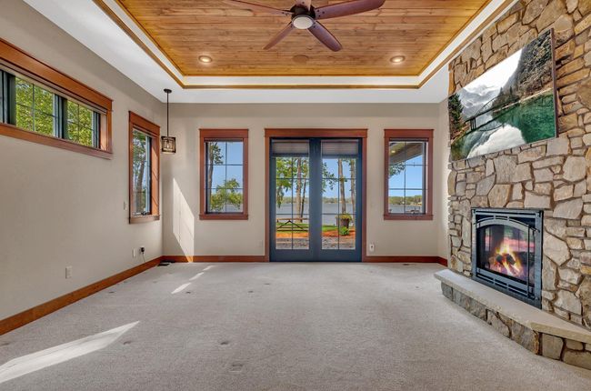 The Primary bedroom with its large floor-to-ceiling windows frame a breathtaking view of the lake and a stone fireplace will add ambience. | Image 46