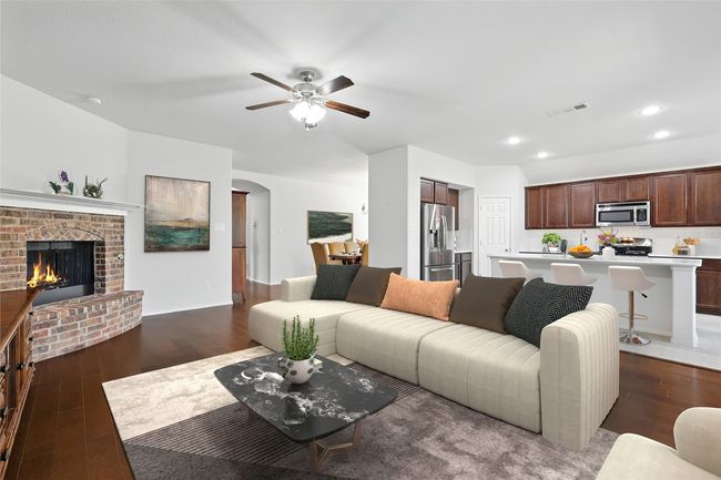 Living area featuring a brick fireplace, wood finished floors, visible vents, and a ceiling fan | Image 19