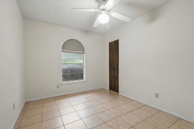 Spare room with light tile patterned floors, a textured ceiling, ceiling fan, and baseboards | Image 30