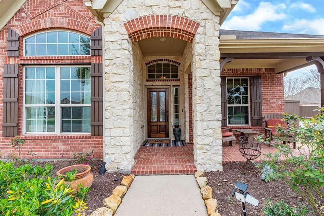 Stone and brick columns line the front walkway to the front porch and entryway of the home. | Image 10