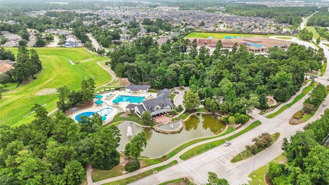 The neighborhood is a lush residential area with a community center featuring multiple pools surrounded by green spaces. | Image 43