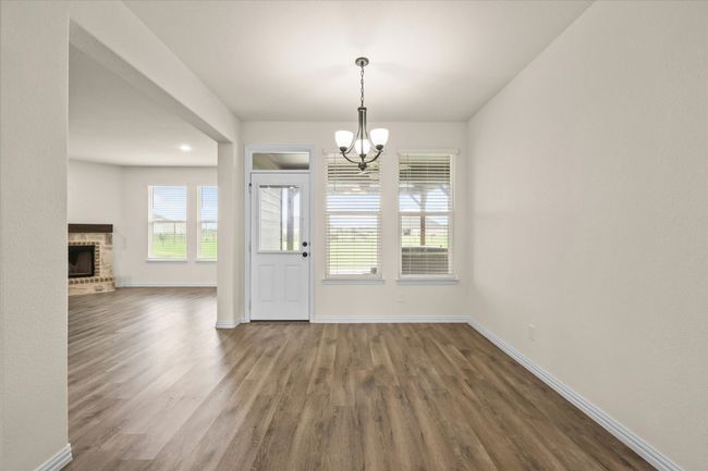 Entrance foyer featuring a chandelier, wood finished floors, and a fireplace | Image 11