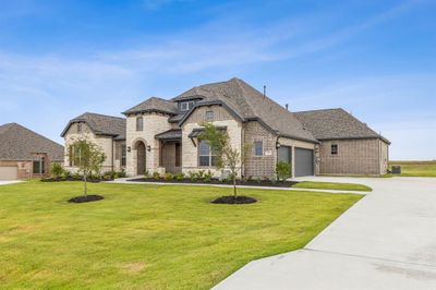 French country home with a garage and a front lawn | Image 2