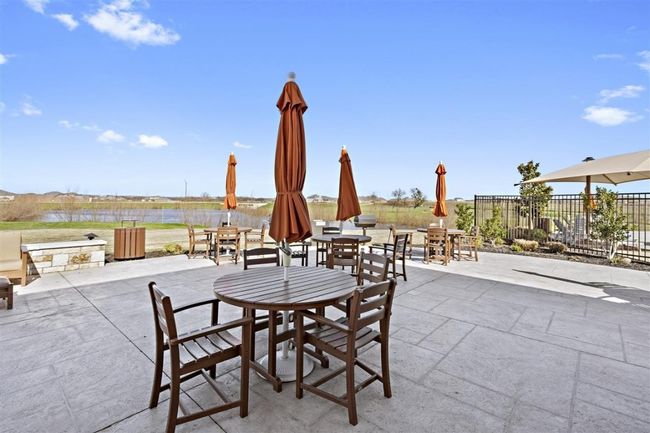 View of patio / terrace featuring fence, outdoor dining space, and a water view | Image 33