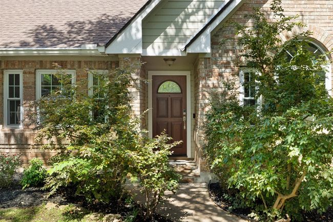 Entrance to property with a shingled roof and brick siding | Image 4