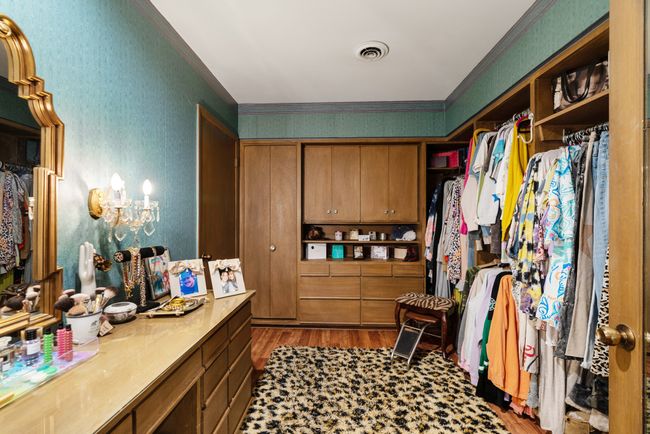 Walk in closet with wood finished floors and a chandelier | Image 20