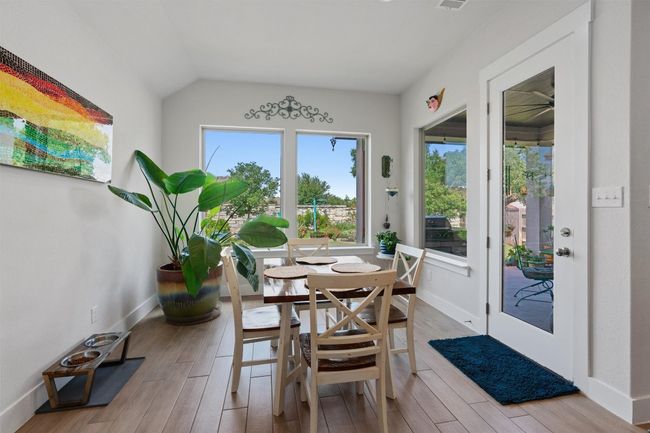 Dining room with wood finished floors, baseboards, lofted ceiling, and ceiling fan | Image 12