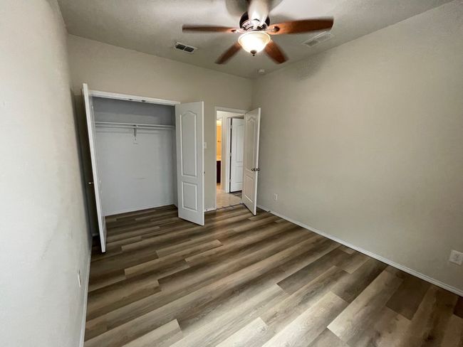 Unfurnished bedroom with wood finished floors, a closet, and a ceiling fan | Image 24