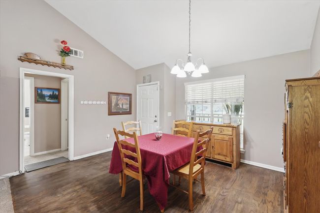 Dining area with a chandelier, baseboards, visible vents, and dark wood-style floors | Image 6