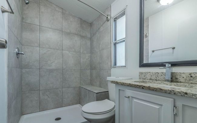 Full bath featuring vanity, tiled shower, and a textured ceiling | Image 13