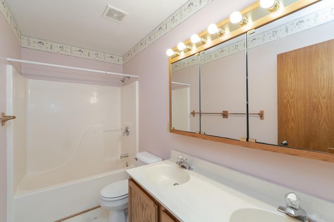 Main floor full bath with double vanity and cabinet storage | Image 16