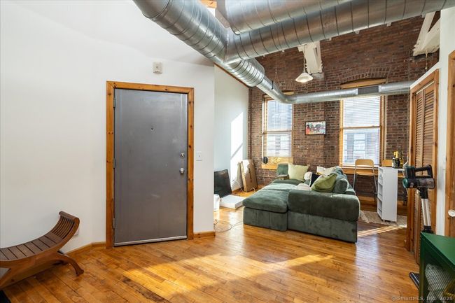 Going through the entry way from the bedrooms towards the living room and kitchen area | Image 14