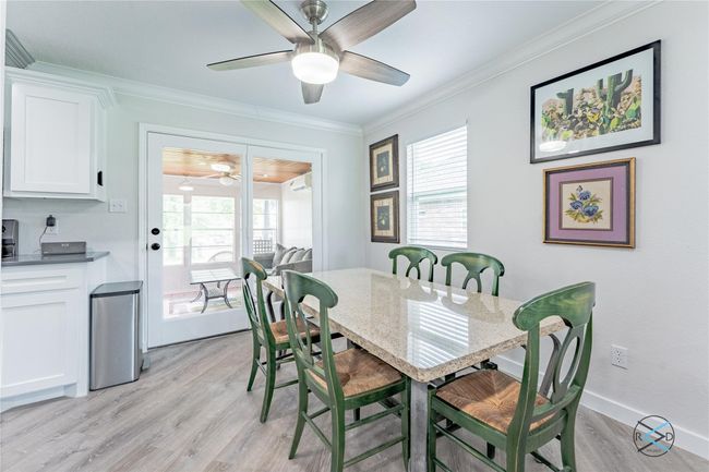Dining room with ceiling fan, crown molding, a healthy amount of sunlight, and light hardwood / wood-style flooring | Image 22