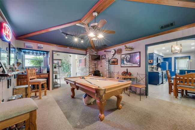 Playroom with carpet, pool table, ceiling fan, tile patterned flooring, and wooden walls | Image 11