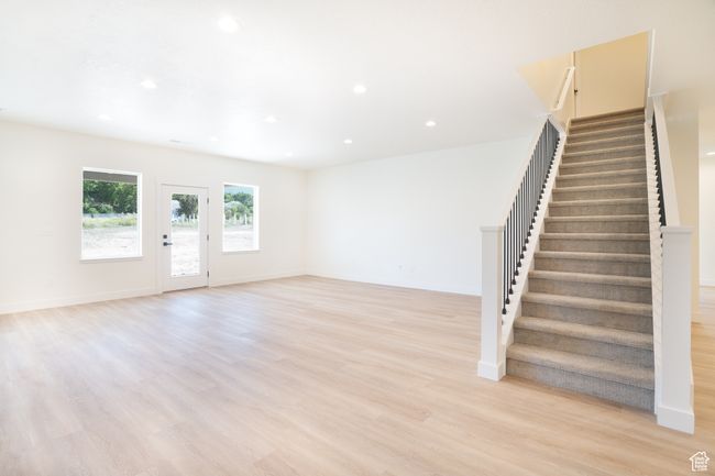 Unfurnished living room featuring stairway, recessed lighting, and light wood-style flooring | Image 11