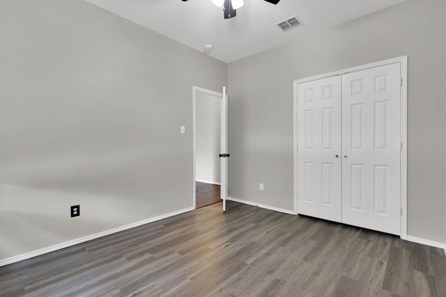 Unfurnished bedroom featuring wood finished floors, baseboards, a closet, and ceiling fan | Image 15