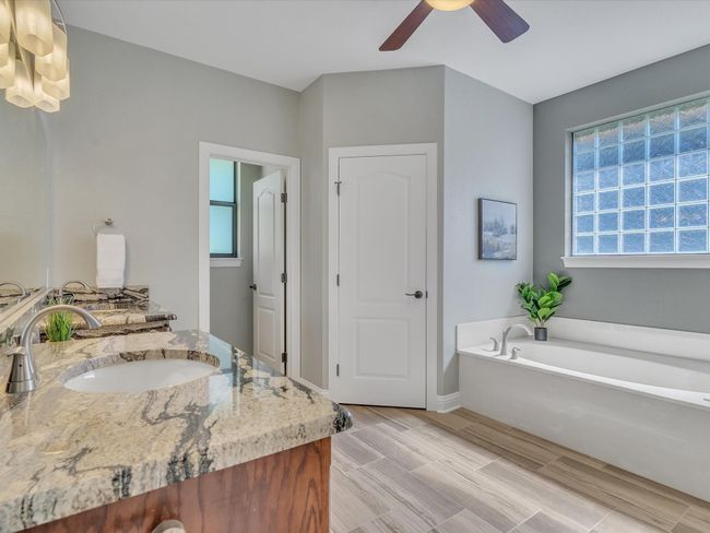 Full bath featuring ceiling fan, a garden tub, vanity, and baseboards | Image 20