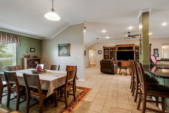 Dining area with recessed lighting, vaulted ceiling, a ceiling fan, ornamental molding, and light tile patterned floors | Image 7