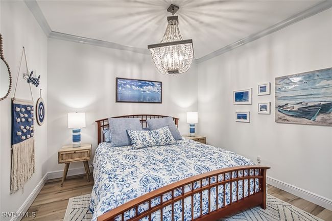 Bedroom featuring a chandelier, ornamental molding, and wood finished floors | Image 41