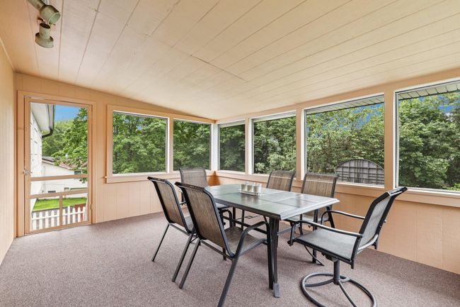 Sunroom featuring outdoor dining area and vaulted ceiling | Image 18