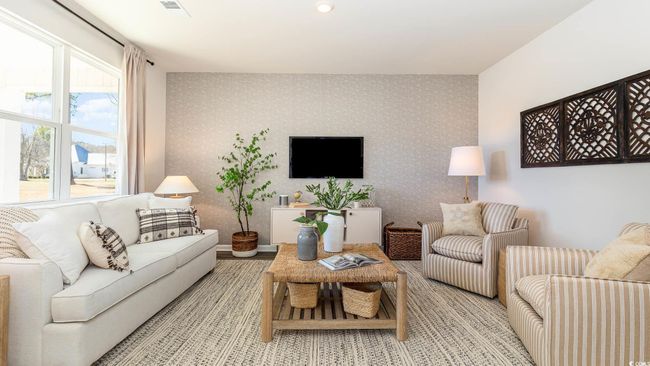 Living area with plenty of natural light, an accent wall, visible vents, and wallpapered walls | Image 11