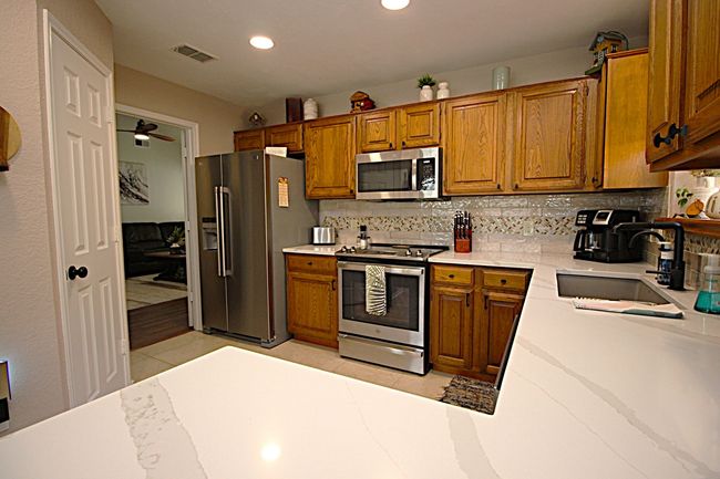 Kitchen with light tile, appliances with stainless steel finishes, and a deep sink | Image 19