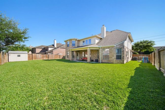 A view of the back of the home and large side yard. The fence was replaced in 2023. | Image 45