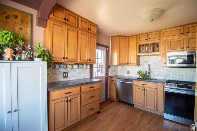 Kitchen with a sink, dark wood finished floors, dark countertops, and stainless steel appliances | Image 6