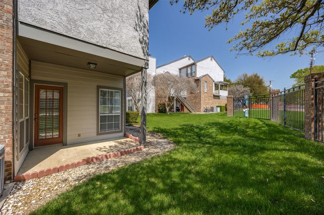 Walk-out from living area to private covered patio, this corner unit is on an open grassy space. | Image 14