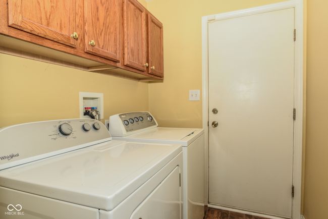washroom featuring washing machine and clothes dryer and cabinet space | Image 15