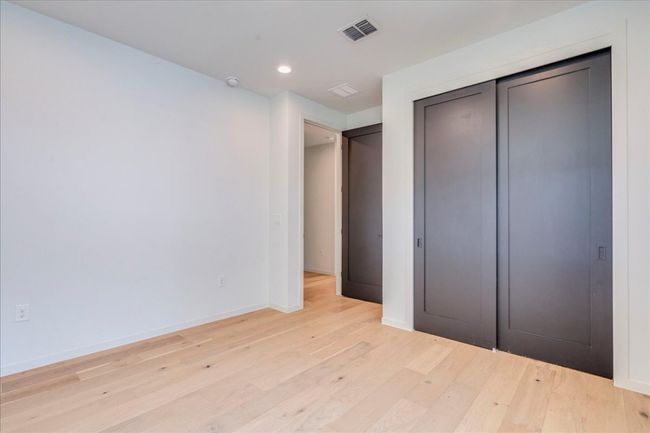 Unfurnished bedroom featuring light wood-style floors, recessed lighting, and a closet | Image 19
