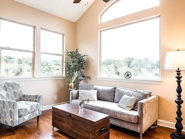 Living area with lofted ceiling, baseboards, ceiling fan, and wood finished floors | Image 12