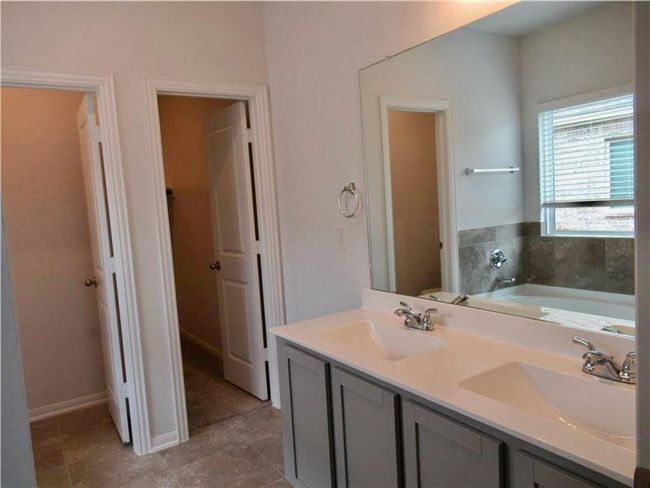 Full bathroom featuring a bath and double vanity | Image 12