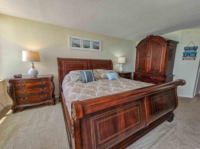 Carpeted bedroom featuring a textured ceiling and baseboards | Image 23