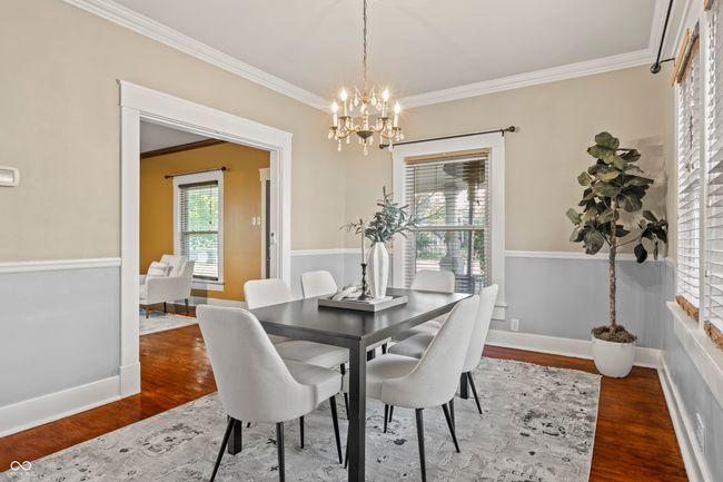 dining room with crown molding, dark wood-type flooring, and a chandelier | Image 14