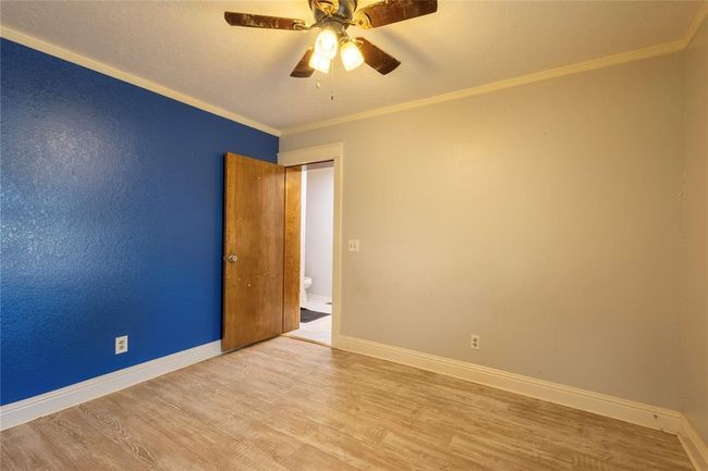 Detailed view of baseboards, a glass covered fireplace, crown molding, and a sink | Image 17