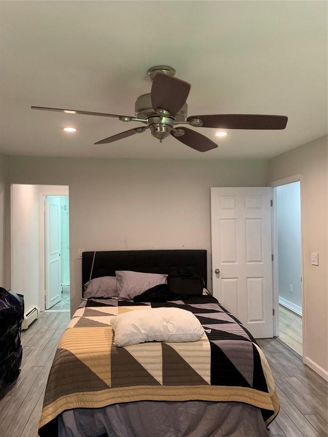 Bedroom featuring baseboard heating, light wood-type flooring, recessed lighting, and a ceiling fan | Image 4