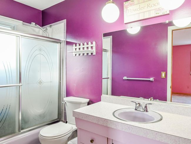 Full bathroom with shower / bath combination with glass door, vanity, and toilet | Image 11