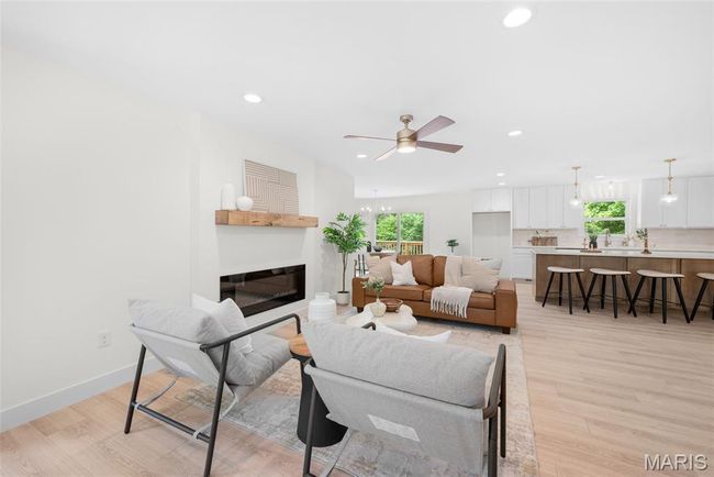 Living room with plenty of natural light, ceiling fan, a glass covered fireplace, recessed lighting, and light wood-type flooring | Image 8