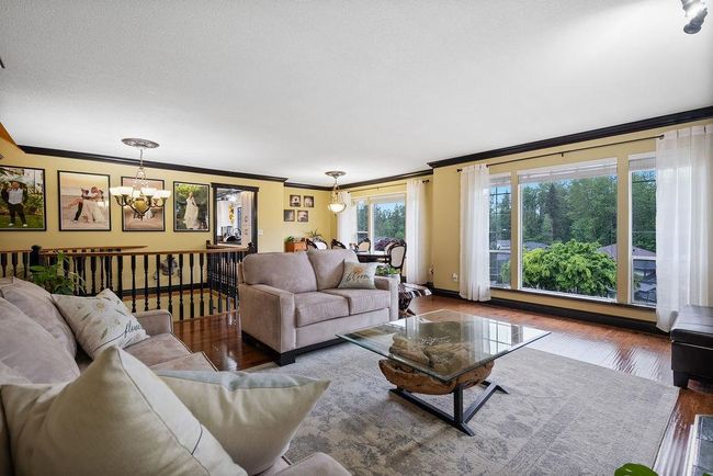 Living area featuring a chandelier, ornamental molding, and wood finished floors | Image 5