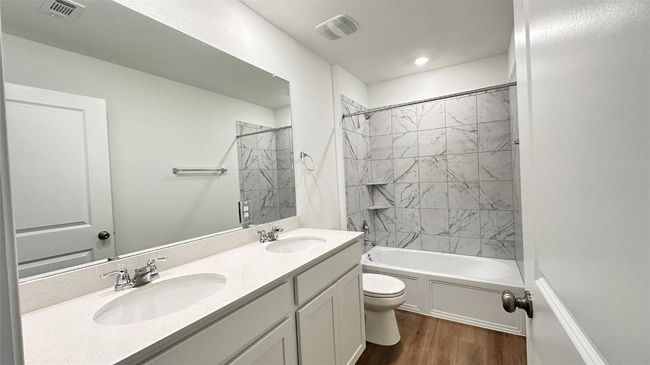 Bathroom featuring visible vents, a sink, wood finished floors, and toilet | Image 5