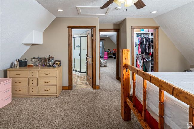Bedroom featuring vaulted ceiling, light carpet, a textured ceiling, and a closet | Image 19