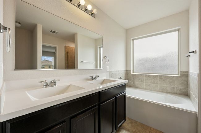 Bathroom with healthy amount of natural light, a garden tub, double vanity, and tile patterned floors | Image 26