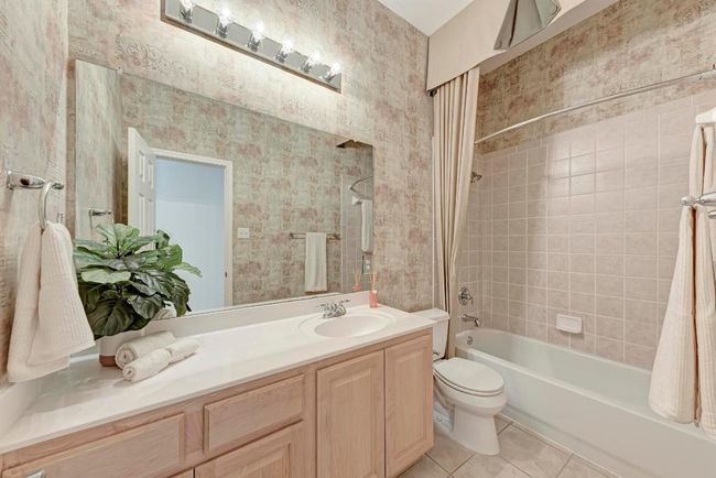 Bathroom with vanity, wallpapered walls, shower / washtub combination, tile patterned floors, and toilet | Image 28