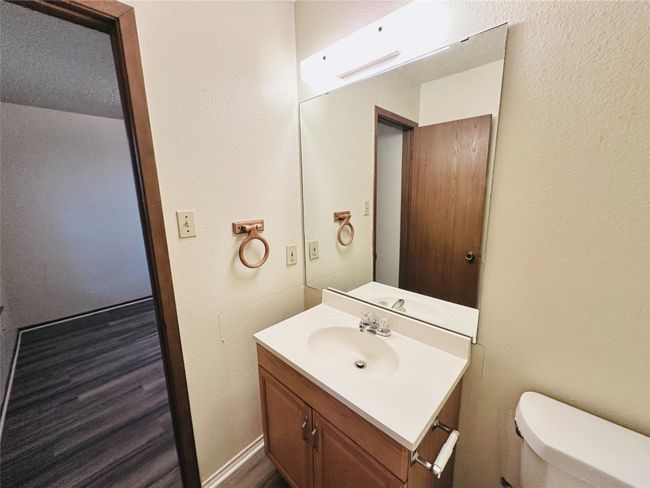 Half bath featuring a textured wall, vanity, and wood finished floors | Image 30