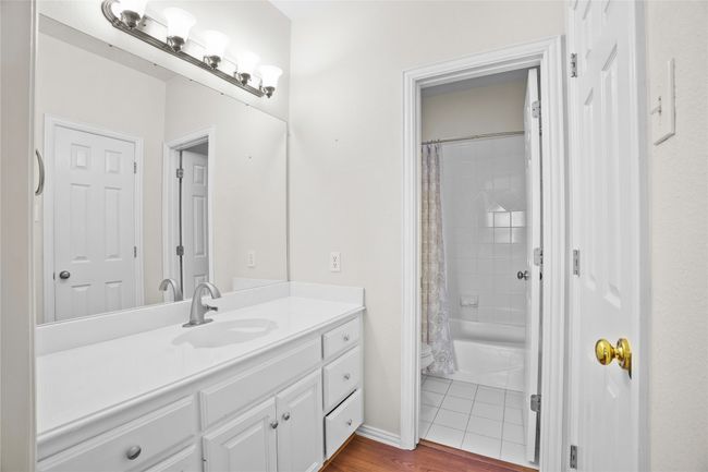 Full bathroom featuring vanity, shower / tub combo with curtain, and wood finished floors | Image 28