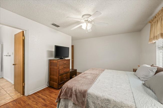 Bedroom with a textured ceiling, light wood-type flooring, and a ceiling fan | Image 21