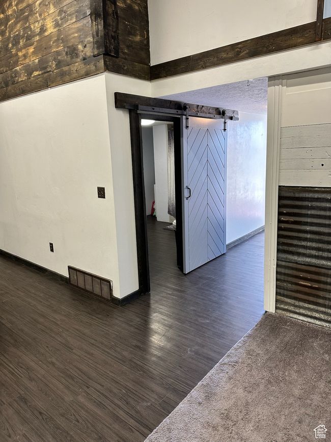 Spare room with dark hardwood / wood-style flooring and a barn door | Image 25