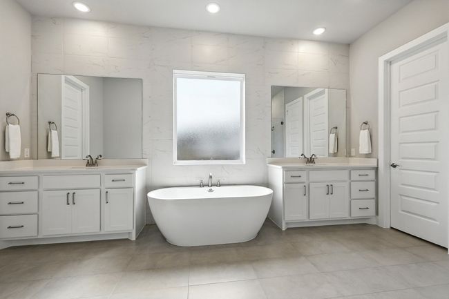 Bathroom featuring two vanities, a freestanding bath, tile patterned flooring, and recessed lighting | Image 15