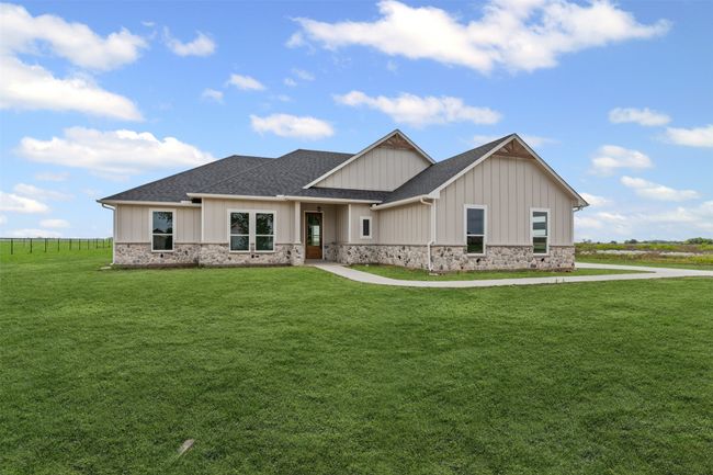 View of front of house featuring a shingled roof, a front lawn, board and batten siding, and stone siding | Image 4